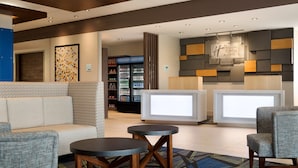 Zona de recepción con asientos, mostrador de información y refrigerador para bebidas.