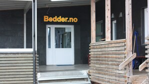 Um canteiro de obras com uma porta branca, degraus de madeira e materiais de construção.