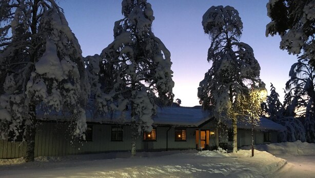 A snow-covered building with multiple windows and a visible entrance. - Torpomoen (Al)