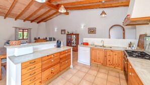 Una cocina con armarios de madera, una isla central, un fregadero y una estufa.