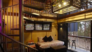 A cozy interior with a bed, a small table, and a staircase. - Treehouse #3, Tri-Level, Large BBQ. Amazing views (Austinville)