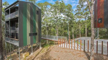 Stunning multi-level building with a balcony and contemporary design, surrounded by a natural environment.
