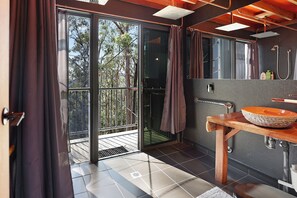 A modern bathroom with a large window, a wooden vanity, and a shower area. - Treehouse #3, 3 Levels, Large BBQ. Amazing views (Austinville)