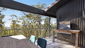 An outdoor patio with a wooden table and chairs, a grill, and a view of trees and mountains. - Treehouse #3, Tri-Level, Large BBQ. Amazing views (Austinville)