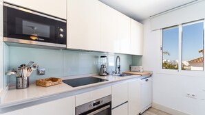 Une cuisine moderne équipée d’un four à micro-ondes Bosch, d’un four Bosch, d’un évier et d’une fenêtre offrant une vue agréable.
