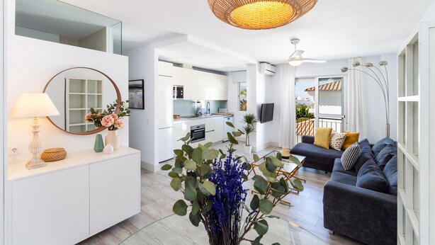 Un salon moderne comprenant un canapé, un coin repas et une cuisine.