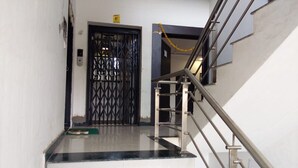 A staircase with a metal handrail and a black metal gate at the top.