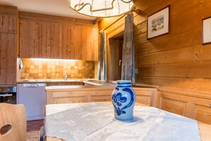 A wooden interior with a table, a vase, and a sink.