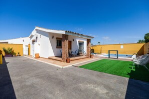 Une propriété résidentielle dotée d’une terrasse, d’une piscine et d’une pelouse bien entretenue.