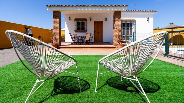 A house with a patio, two chairs, a table, and a door. - Rustic Home Close to Beach with Pool, Terrace, Garden & Wi-Fi; Pets Allowed, Parking Available (Conil de la Frontera)