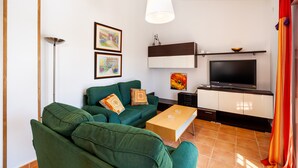 A living room with a sofa, a coffee table, a TV, and a cabinet. - Rustic Home Close to Beach with Pool, Terrace, Garden & Wi-Fi; Pets Allowed, Parking Available (Conil de la Frontera)