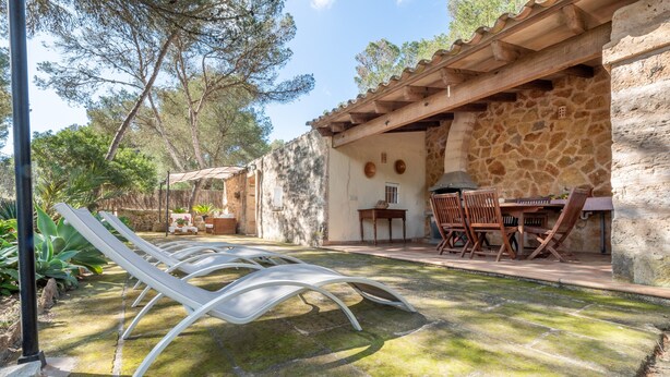 Een terras met loungezetels, een tafel en een barbecuehoek.