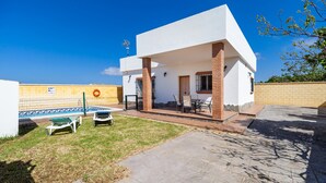 Una casa moderna con patio, piscina e un muro in mattoni.