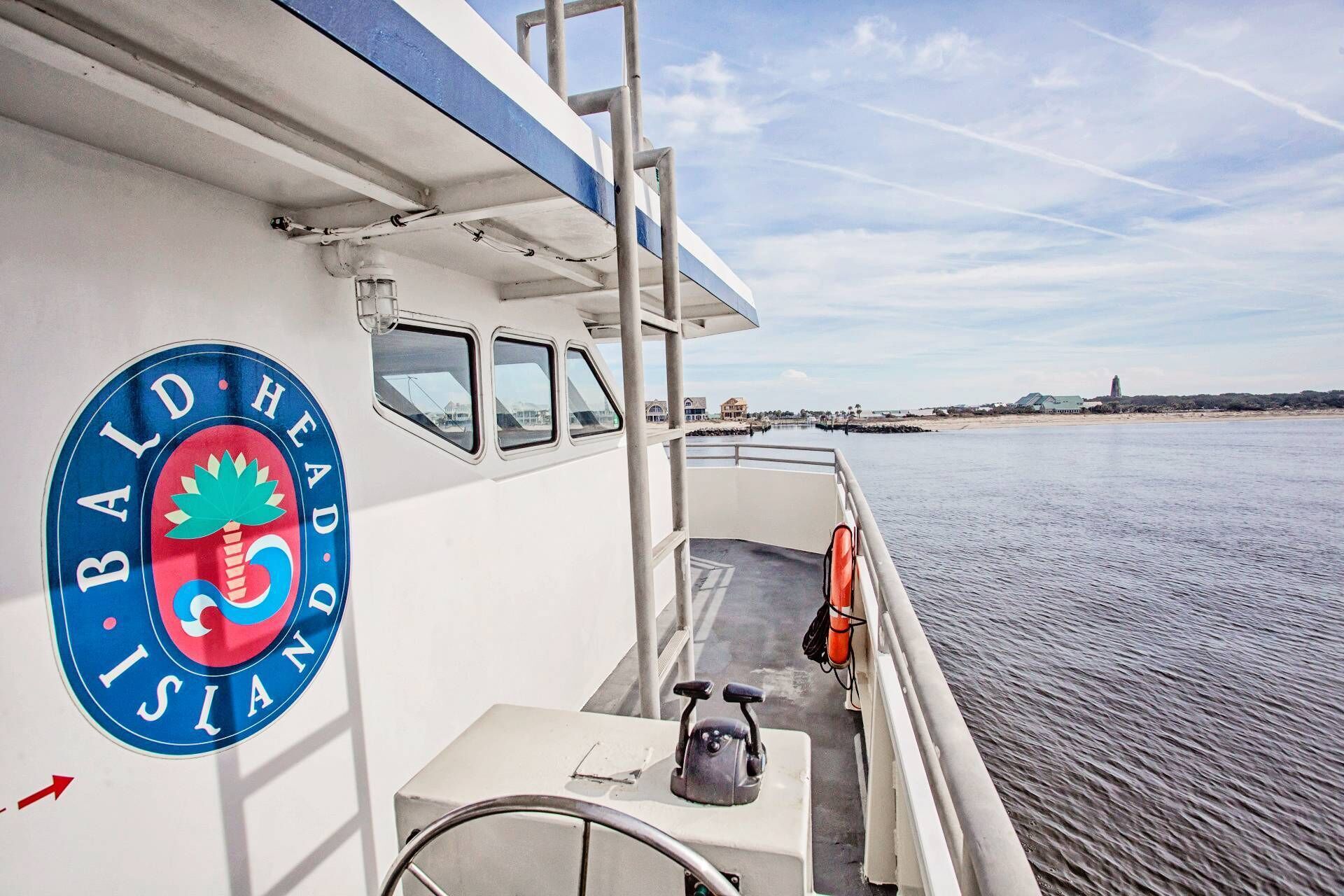 A boat with a logo on the side, a steering wheel, and a lifebuoy.