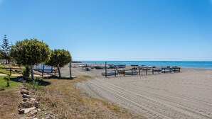 A beach with boats, a clear sky, and a tree. - Beachfront Apartment with Air Conditioning, Stunning Views, Terrace, and Wi-Fi (Benajarafe)