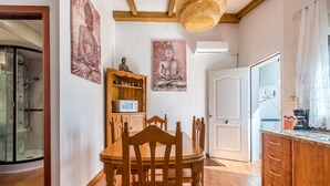 A room with a wooden dining table, chairs, a cabinet, and two Buddha statues on the wall. - Beachfront Apartment with Air Conditioning, Stunning Views, Terrace, and Wi-Fi (Benajarafe)