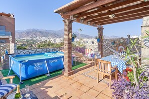 A rooftop terrace with a pool, outdoor seating, and a view of the city and mountains. - Air-Conditioned Apartment Close to Beaches with Rooftop Terrace (Nerja)