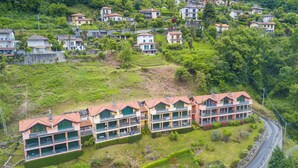 Un quartiere residenziale con una fila di edifici a più piani, balconi e una strada tortuosa.