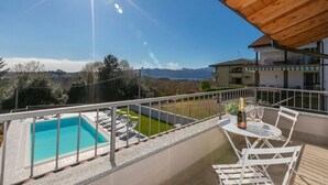 A balcony with a pool, outdoor seating, and a view of mountains. - Villa Il Gelsomino Bellavista (Besozzo)