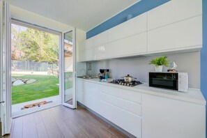 A modern kitchen with a sliding glass door leading to a backyard.