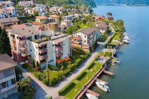 A residential area with modern buildings, a marina, and a lake. - Casa Bader (Riva San Vitale)