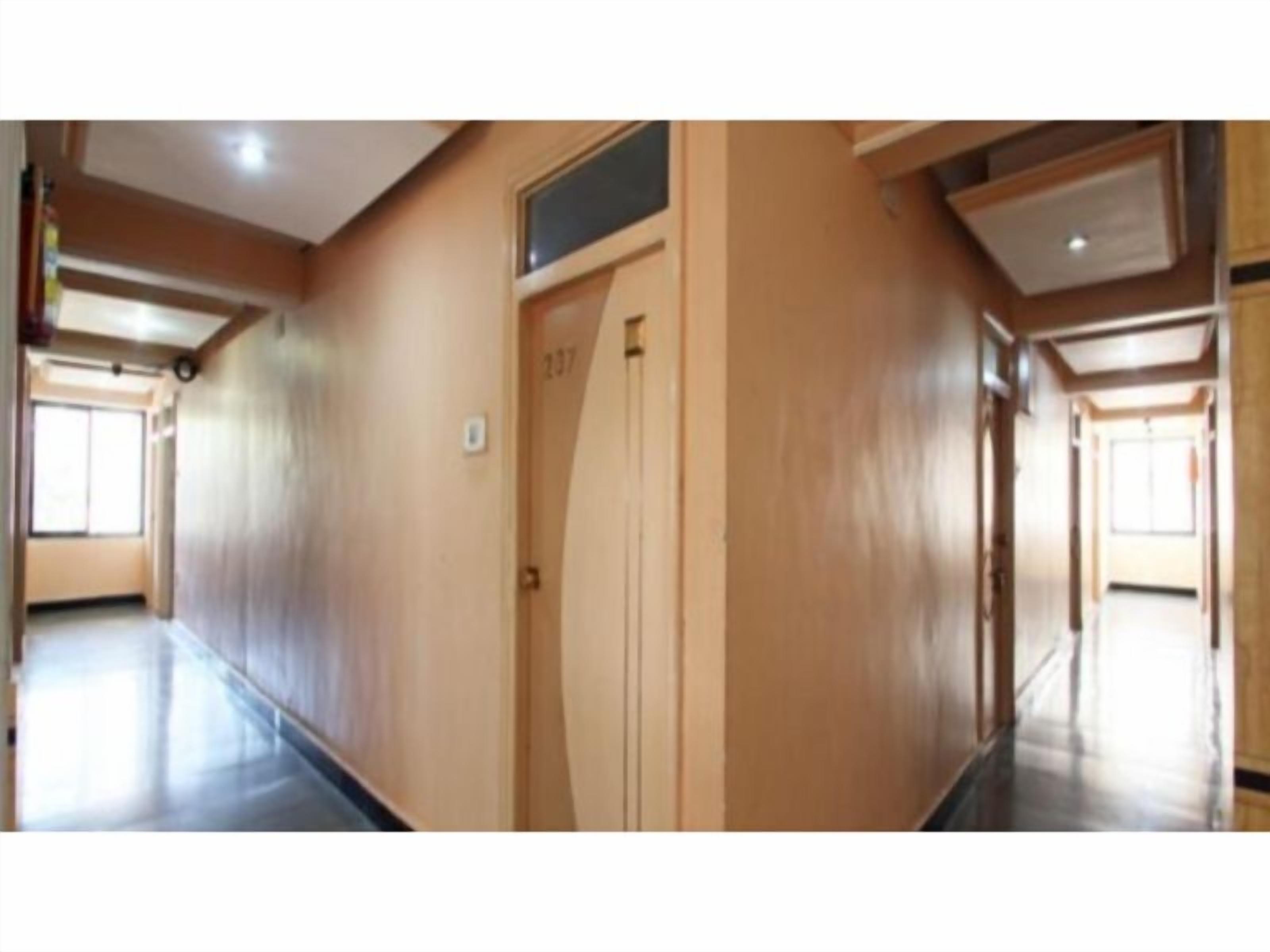 Un pasillo con paredes de madera y una puerta con el número 237.