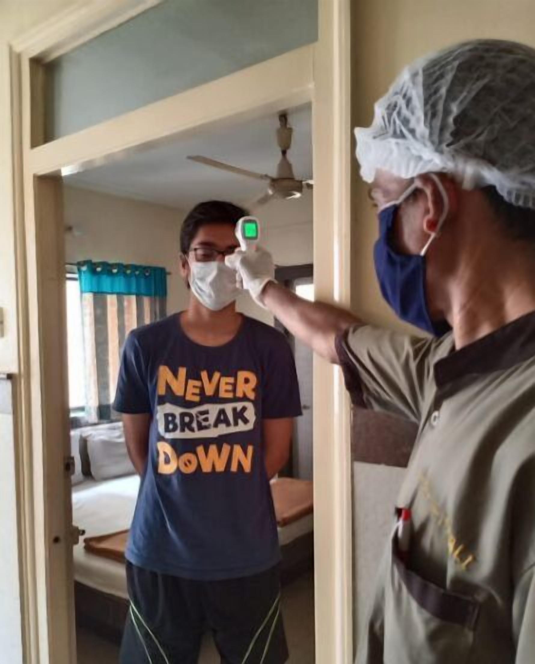 Una persona con camiseta que dice 'NEVER BREAK DOWN' de pie en un umbral.