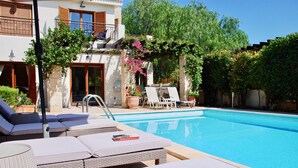 A poolside area with lounge chairs and a pool. - Villa HG28 - Loukia (Kouklia)