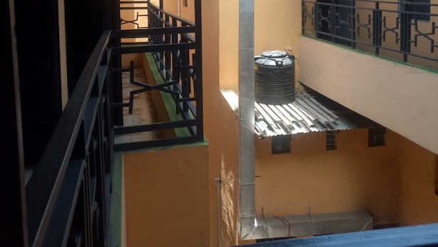 A multi-level building with balconies, staircases, and a water tank. - Jackmart Lodge - Adults Only (Nakuru)