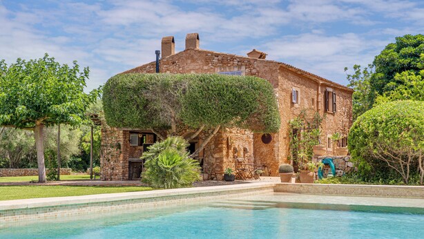 A stone villa with a swimming pool, surrounded by lush greenery and trees. - Mediterranean country house with Wi-Fi, Pool and Garden (Cala Mondrago)