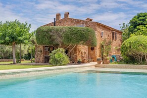 A stone villa with a swimming pool, surrounded by lush greenery and trees. - Mediterranean country house with Wi-Fi, Pool and Garden (Cala Mondrago)