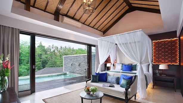A modern bedroom with a large window, a bed with white and blue bedding, and a view of a swimming pool. - Choose Kigali (Kigali)