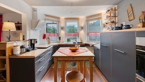 Une cuisine compacte dotée d’un îlot central, de meubles en bois et d’une fenêtre offrant une belle vue.
