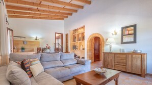 Una sala de estar con un sofá, una mesa de centro de madera, un armario y una chimenea.