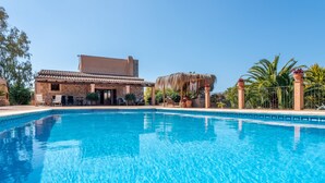 Una piscina con un edificio de piedra al fondo.