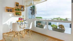 Un comedor con una mesa, sillas y plantas en macetas.