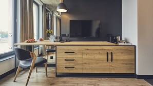 Una cucina moderna con un'ampia isola, mobili in legno e un grande televisore.