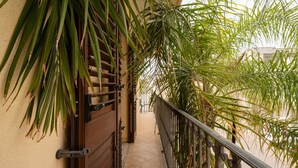 A corridor with a tiled floor, a metal railing, and green foliage. - Historical charm in Racale (Racale)