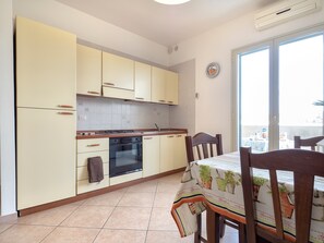Une cuisine équipée de placards, d’une cuisinière, d’un four et d’un coin repas avec des chaises et une table.