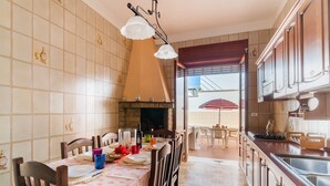 Eine Küche mit Essbereich, Kamin und Blick durch eine Glastür.