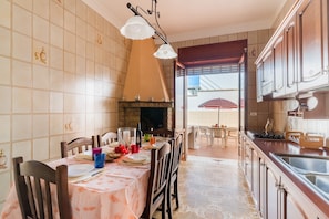 Keittiössä on ruokailutila, takka ja lasiovesta avautuva näkymä.