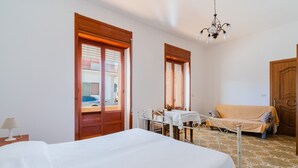 Ein Hotelzimmer mit Bett, Tisch, Sofa und einer Chandelier.