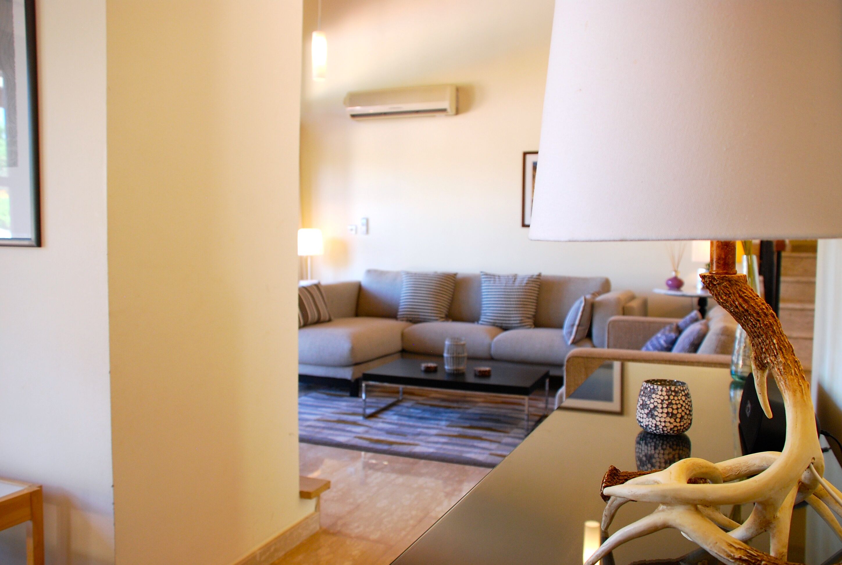 Ein modernes Wohnzimmer mit einer Couch, einem Couchtisch und Dekorationselementen.