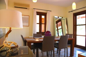 A dining area with a table set for four, a lamp, and a decorative piece on the table.