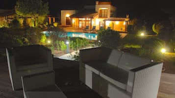 Vista frontal de la propiedad por la tarde o noche