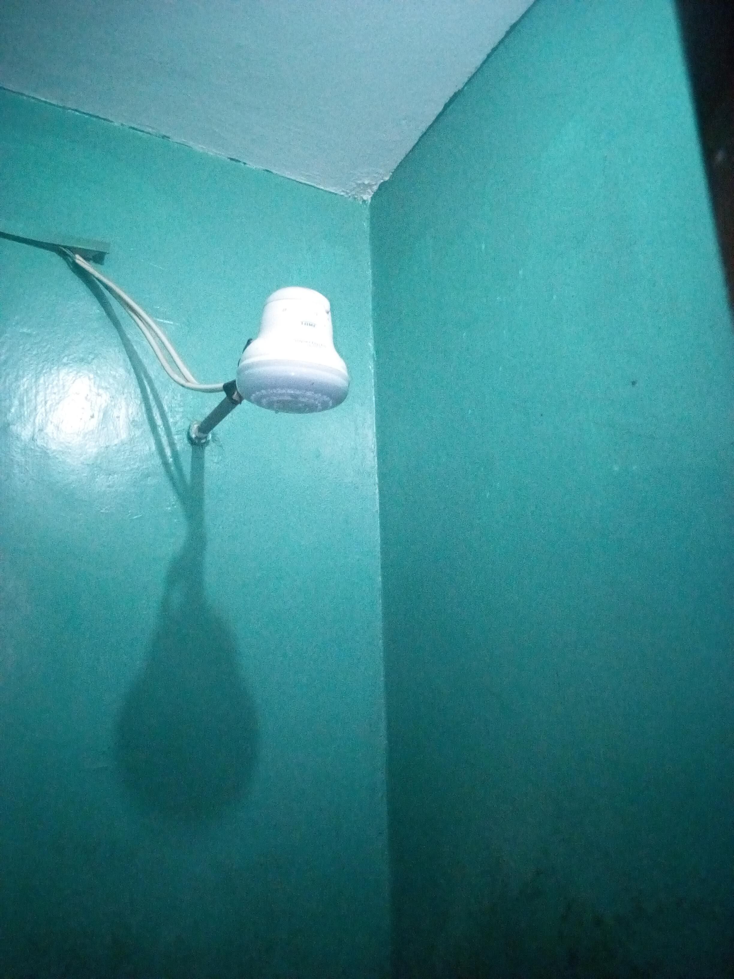 Una cámara de seguridad blanca montada en una pared azul verdoso.