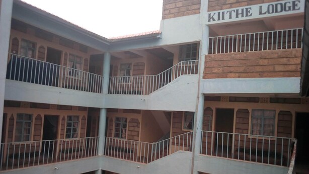 A multi-story building with balconies and a sign that reads "KITTHE LODGE".