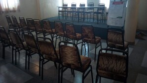 A conference room with a stage, rows of chairs, and a whiteboard with a 'Special Offer' sign.