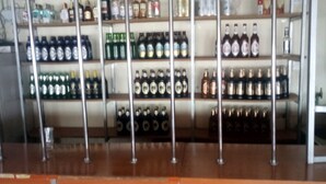 A bar area with shelves stocked with various bottles of alcohol.