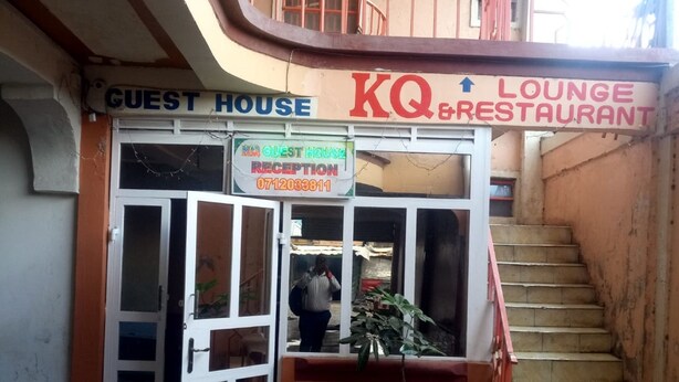 A building with a sign for a guest house and a lounge restaurant.